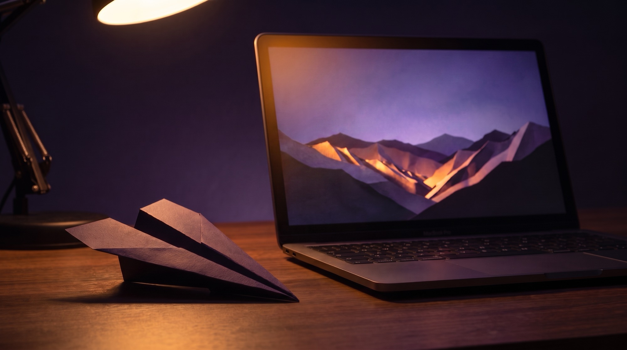 Paper airplane landed beside a laptop